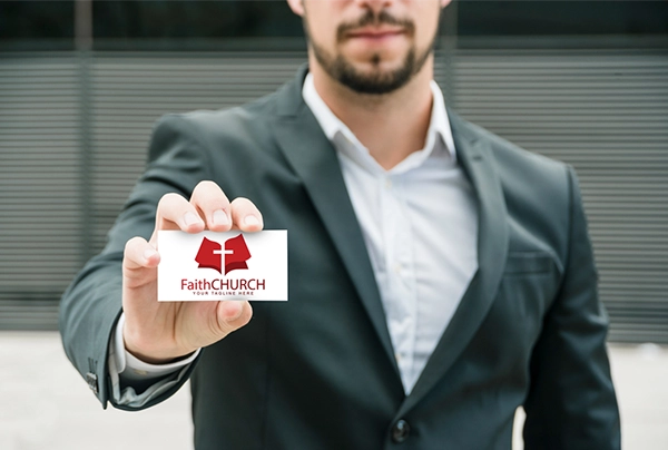 Picture of man holding Faith Church logo business card